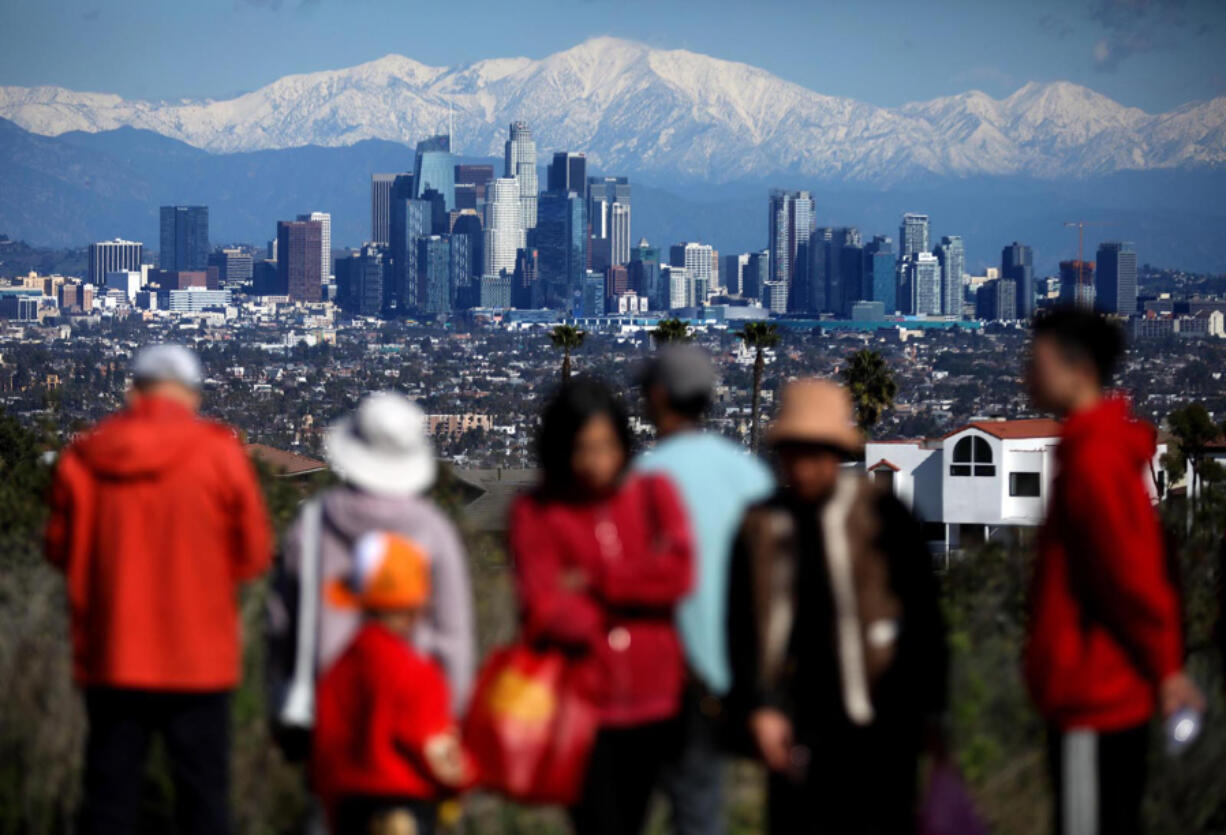 Newly snow-capped San Gabriel Mountains enhance the view of downtown Los Angeles from the Kenneth Hahn State Recreation Area in Baldwin Hills on Saturday.