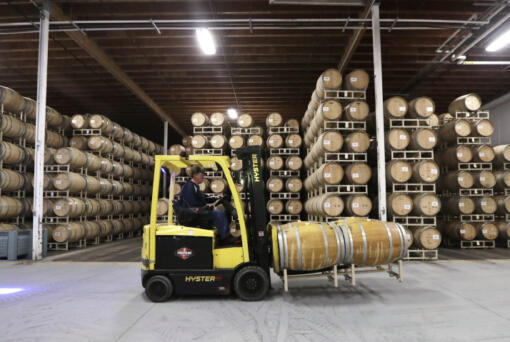 In this photo taken Thursday, Nov. 21, 2019, barrels of wine are moved into storage at Chateau Ste. Michelle winery in Woodinville.