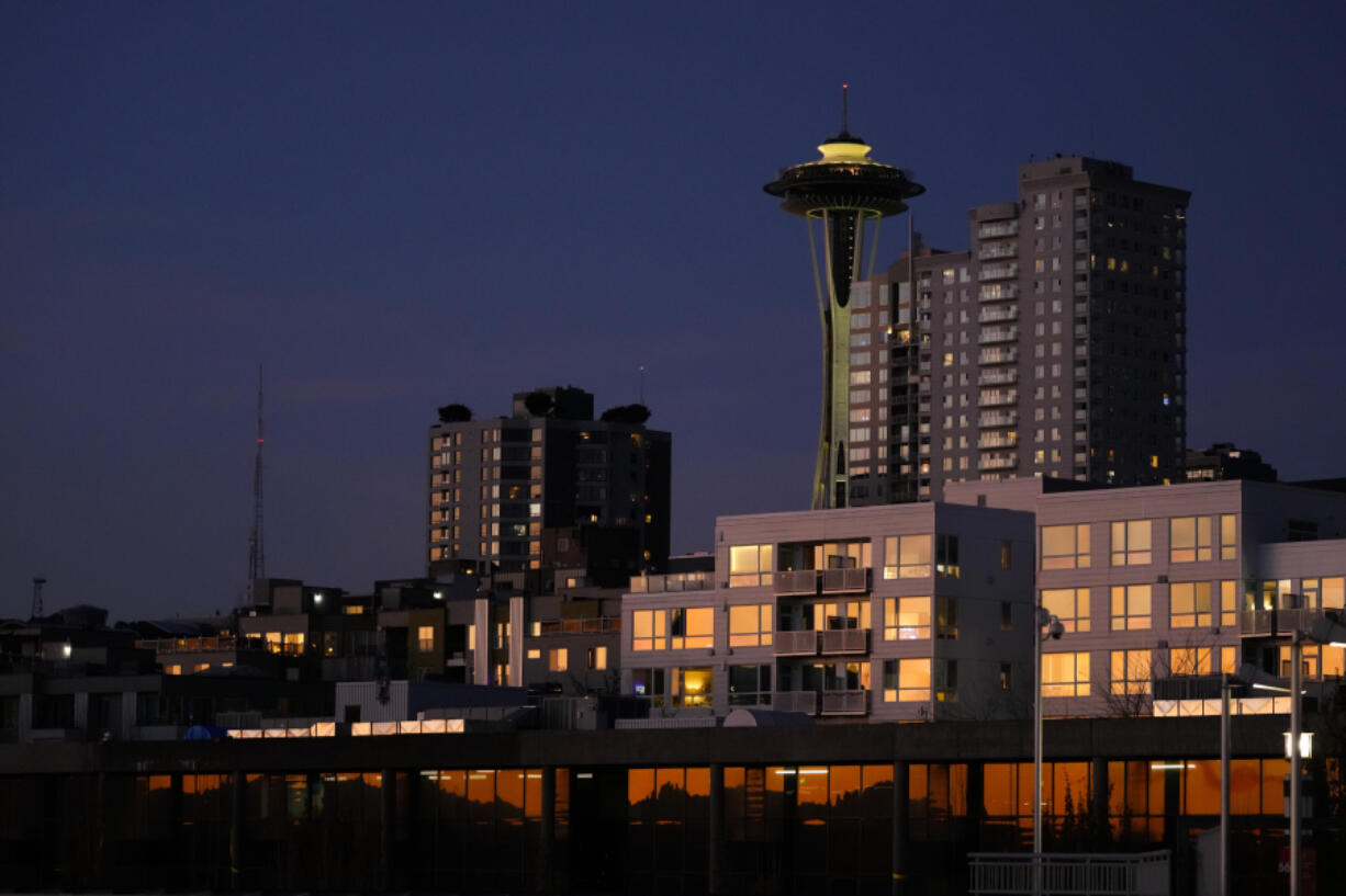 The Space Needle is seen as the setting sun reflects off of nearby apartments, Sunday, Oct. 29, 2023, in Seattle.
