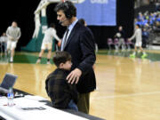 Mark Morris boys basketball coach Bill Bakamus does a radio interview next to his grandson after a 51-47 loss to Bremerton in the Class 2A state tournament Wednesday, Feb. 28, 2024 in Yakima. The round of 12 loss ended the 41-year coaching career for Bakamus.