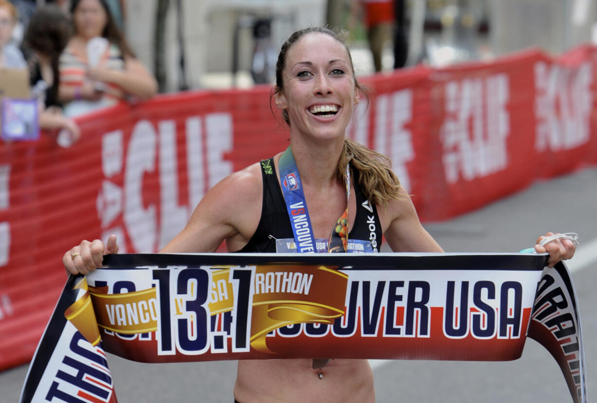 Sarah Crouch holds up the finish line banner after winning a half marathon on June 21, 2015 in Vancouver. The former standout runner at Western Washington University and Hockinson High alum will be going into the WWU athletics hall of fame, the school announced Thursday, Feb. 29, 2024.