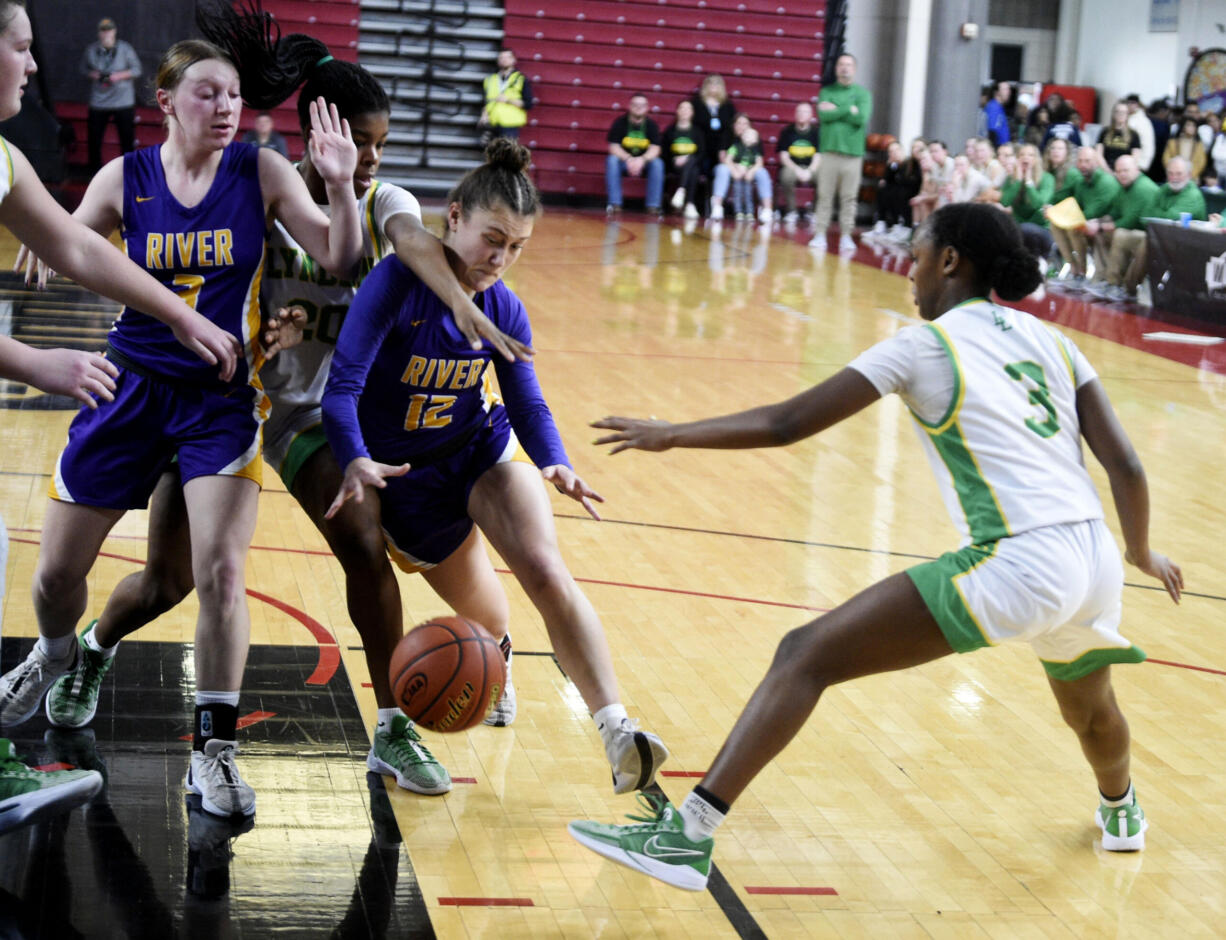 Columbia River's Paige Johnson drives to the basket by Lynden's Kiki York (20) and Columbia River's Marley Myers (3) during a Class 2A girls basketball state quarterfinal game on Thursday, Feb. 29, 2024 in Yakima.