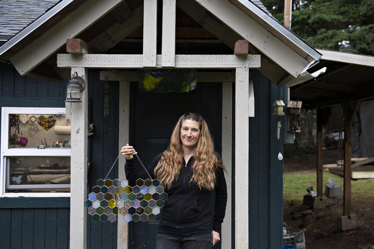 Artist Kristin Culotta takes a break outside her rural Camas studio with a free-form hexagon panel. Many of her works are custom. &ldquo;I love collaborating with clients on projects in every aspect of the process,&rdquo; Culotta said.