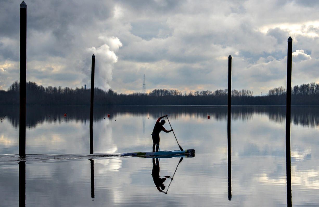 Ted Schatz of Vancouver cruises on a race style stand-up paddleboard at Vancouver Lake on Wednesday morning. The Clark County Council on Tuesday approved a new contract for Lower Columbia Estuary Partnership&rsquo;s education programs at the popular recreation area.