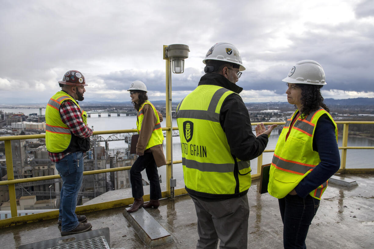 Rob Moravec, from left, maintenance manager for United Grain Corp., takes in a view of the Port of Vancouver with U.S. Rep. Marie Gluesenkamp Perez, United Grain Corp. President and CEO Augusto Bassanini and U.S. Agriculture Deputy Secretary Xochitl Torres Small during a tour Thursday afternoon. They visited to highlight the Biden administration&rsquo;s stated commitment to increasing access to trade and creating new economic opportunities for producers and businesses in Washington and around the country.
