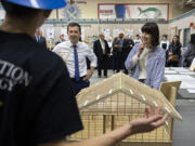 U.S. Department of Transportation Secretary Pete Buttigieg, left, and U.S. Rep. Marie Gluesenkamp Perez chat with construction students during a visit to Cascadia Tech Academy on Monday afternoon. The house the students were designing and building will be the 47th house in Clark County built by Cascadia Tech students, according to Joan Huston, Cascadia Tech director.