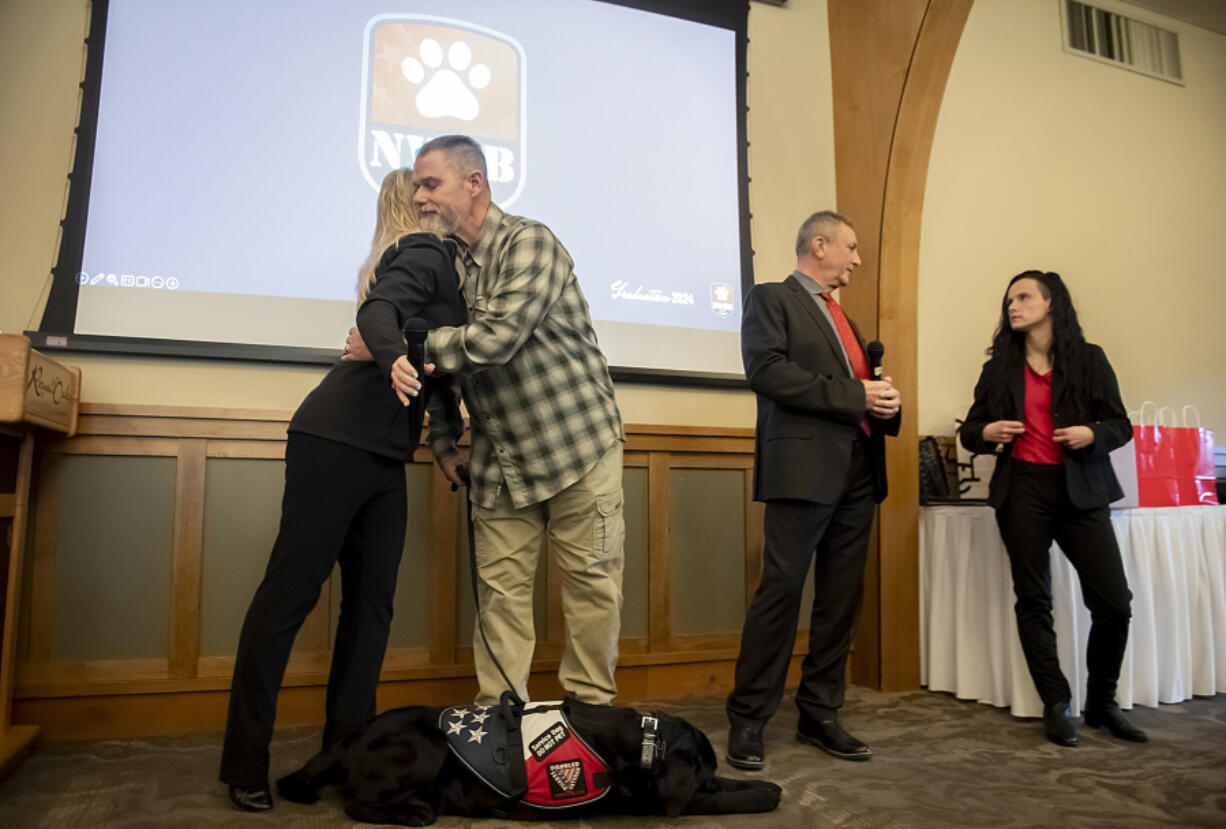 From left: Shannon Walker, founder of Northwest Battle Buddies, shares support with veteran Pete Reddig of Wyoming and his dog, Toby. Northwest Battle Buddies&rsquo; graduation Friday brought together veterans, community members and four-legged friends.