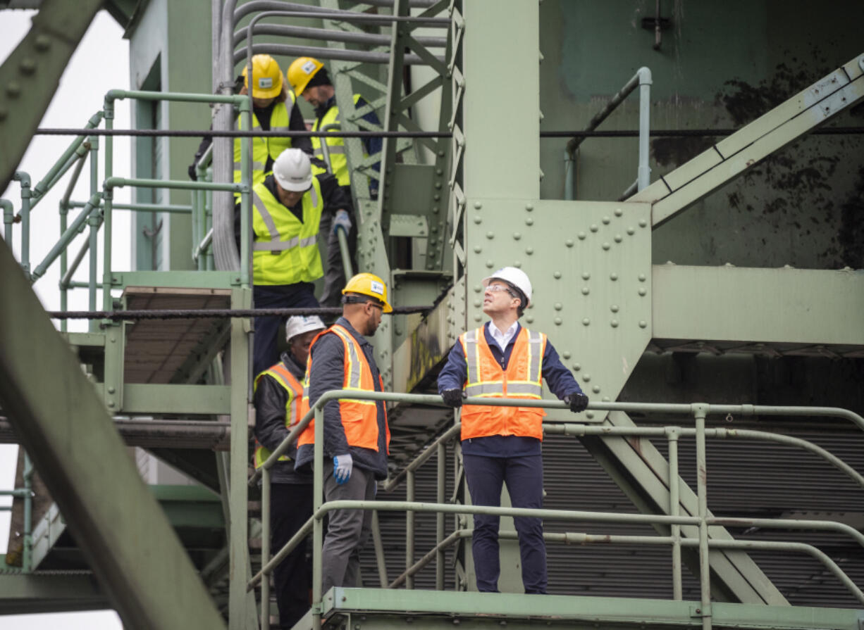 U.S. Department of Transportation Secretary Pete Buttigieg, center, looks around the 107-year-old Interstate 5 Bridge on Tuesday during a tour in Vancouver.