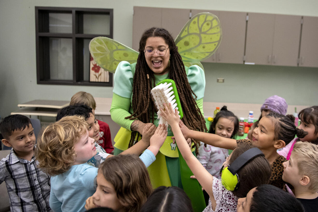 The Tooth Fairy, center, is all smiles Wednesday at Sarah J. Anderson Elementary School in Hazel Dell. Tooth Fairy Jasmine, portrayed by Jasmine Lomax, is one of seven fairies who travel across the state and teach students about the importance of oral health.