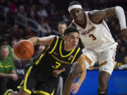 Oregon guard Jackson Shelstad, left, drives to the basket as Southern California forward Vincent Iwuchukwu defends during the second half of an NCAA college basketball game Thursday, Feb. 1, 2024 in Los Angeles.
