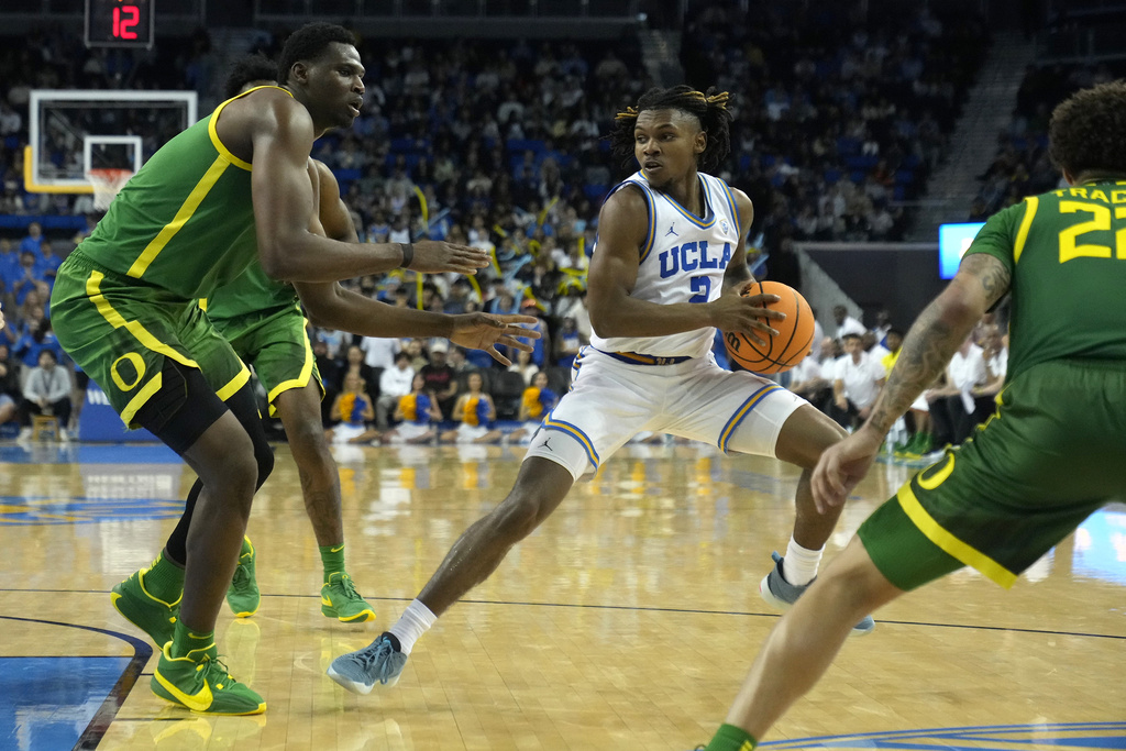 UCLA guard Dylan Andrews (2) pivots against defending Oregon center N'Faly Dante (1), left, during the second half of an NCAA college basketball game in Los Angeles, Saturday, Feb. 3, 2024.