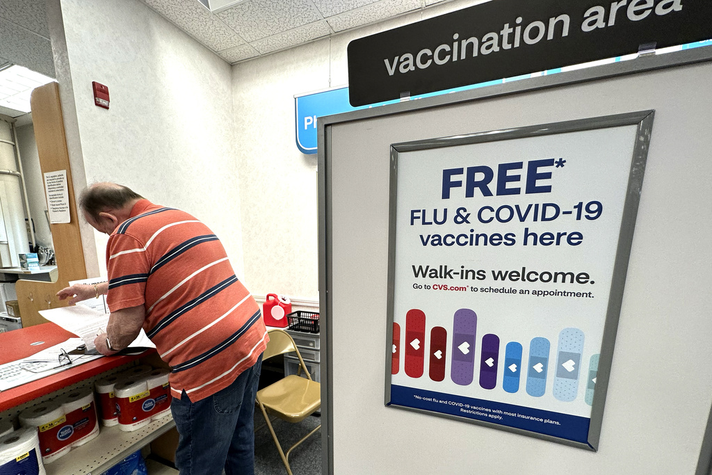 FILE - A sign for flu and covid vaccinations is displayed at a pharmacy store in Palatine, Ill., Wednesday, Sept. 13, 2023. The flu is hanging on in the U.S., intensifying in some areas of the country after weeks of apparent decline., according to data released by the U.S. Centers for Disease Control and Prevention on Friday, Feb. 9, 2024. (AP Photo/Nam Y.