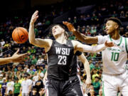 Washington State forward Andrej Jakimovski (23) and Oregon forward Kwame Evans Jr. (10) go for a rebound during the first half of an NCAA college basketball game in Eugene, Ore., Saturday, Feb. 10, 2024.