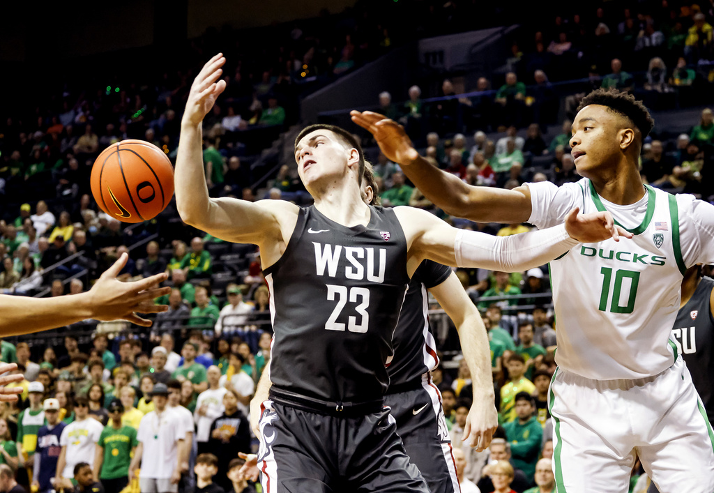 Washington State forward Andrej Jakimovski (23) and Oregon forward Kwame Evans Jr. (10) go for a rebound during the first half of an NCAA college basketball game in Eugene, Ore., Saturday, Feb. 10, 2024.