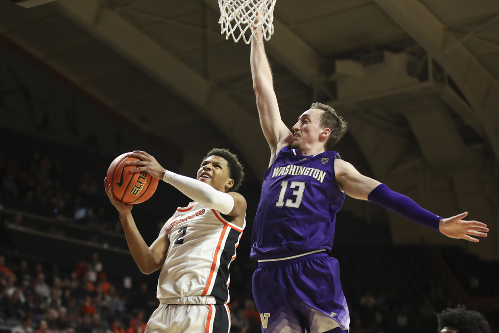 Oregon State guard Josiah Lake II (2) drives to the basket as Washington forward Moses Wood (13) defends during the first half of an NCAA college basketball game Saturday, Feb. 10, 2024, in Corvallis, Ore.