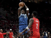 Minnesota Timberwolves guard Anthony Edwards shoots over Portland Trail Blazers center Deandre Ayton during the first half of an NBA basketball game in Portland, Ore., Tuesday Feb. 13, 2024.