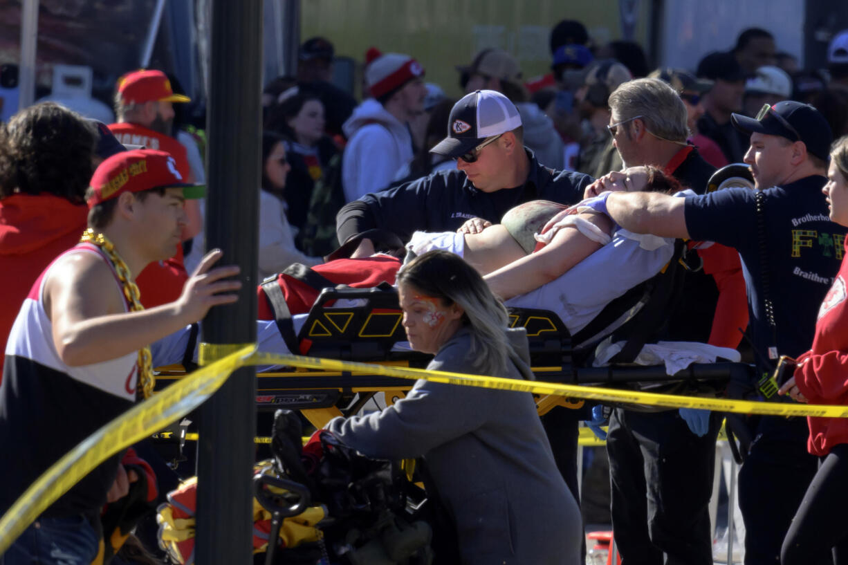 A woman is rushed to an ambulance following a shooting at the Kansas City Chiefs NFL football Super Bowl celebration in Kansas City, Mo., Wednesday, Feb. 14, 2024. Multiple people were injured, a fire official said.