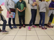 Migrant teens line up for a class at a "tender-age" facility for babies, children and teens, in Texas' Rio Grande Valley, in San Benito, Texas, Aug. 29, 2019.  The Biden administration struggled to properly vet and monitor the homes where they placed a surge of migrant children who arrived at the U.S.-Mexico border in 2021. That's according to a federal watchdog report released Thursday.