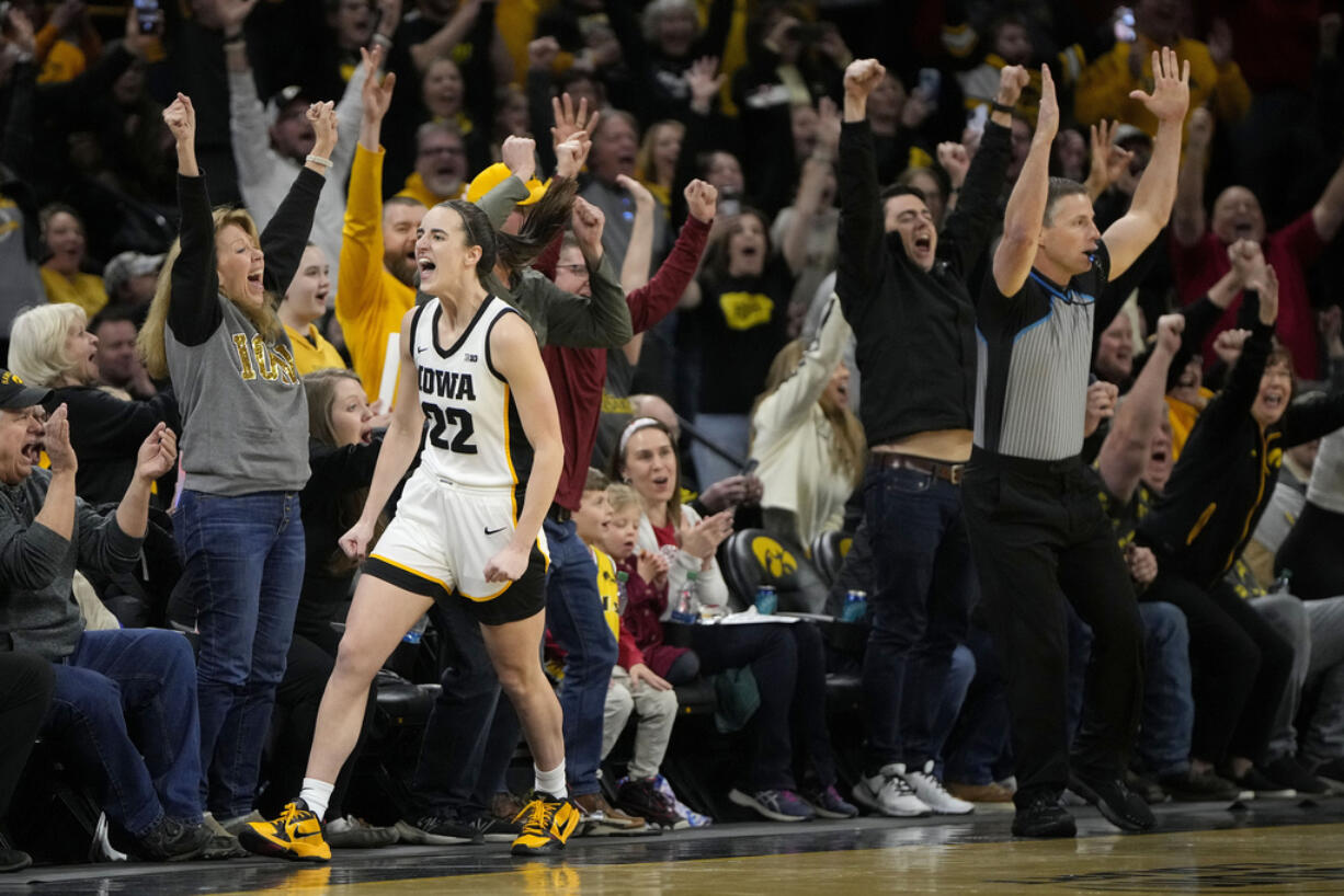 Iowa guard Caitlin Clark (22) reacts after breaking the NCAA women's career scoring record during the first half of the team's college basketball game against Michigan, Thursday, Feb. 15, 2024, in Iowa City, Iowa.