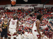 Washington State forward Isaac Jones, right, celebrates his basket next to teammate Rueben Chinyelu (20) during the second half of an NCAA college basketball game against California, Thursday, Feb. 15, 2024, in Pullman, Wash.