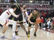 Oregon guard Jackson Shelstad (3) drives as Stanford forward Maxime Raynaud (42) watches during the second half of an NCAA college basketball game Thursday, Feb. 22, 2024, in Stanford, Calif.