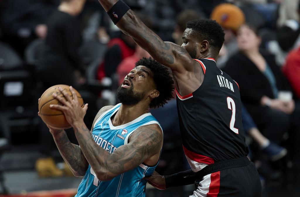 Charlotte Hornets center Nick Richards, left, shoots in front of Portland Trail Blazers center Deandre Ayton during the second half of an NBA basketball game in Portland, Ore., Sunday, Feb. 25, 2024.