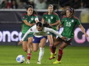 United States forward Sophia Smith, front, falls while vying for the ball against, from back left to right, Mexico defender Rebeca Bernal, midfielder Alexia Delgado and defender Cristina Ferral during a CONCACAF Gold Cup women's soccer tournament match, Monday, Feb. 26, 2024, in Carson, Calif.