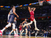 Minnesota Timberwolves forward Karl-Anthony Towns (32) goes up for a dunk during the first half of an NBA All-Star basketball game in Indianapolis, Sunday, Feb. 18, 2024.