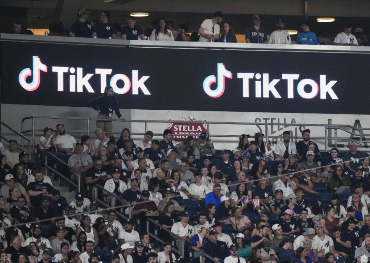 FILE - Fans sit under a TikTok ad at a baseball game at Yankee Stadium, April 14, 2023, in New York. President Joe Biden&rsquo;s campaign is embracing TikTok to court younger voters ahead of the U.S. presidential elections, but U.S. adults seem to be split about whether the video-sharing app should even operate in the country.