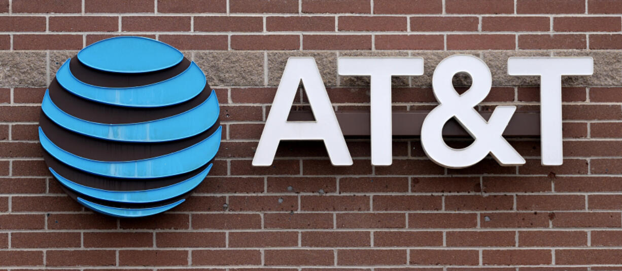FILE - The company logo hangs over the door to an AT&amp;T store Thursday, Feb. 22, 2024, in Denver.