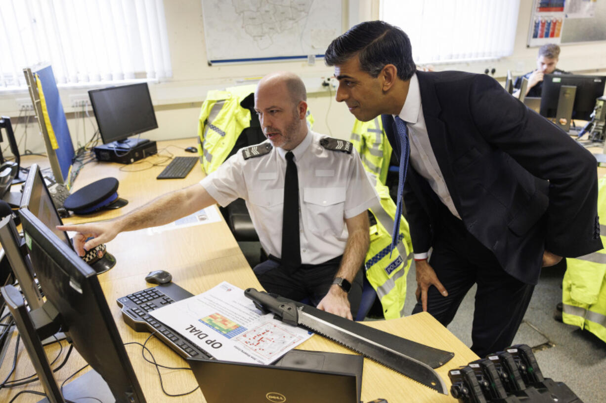 Britain&rsquo;s Prime Minister Rishi Sunak speaks with Police Sergeant Gavin Tuck while visiting Harlow Police Station during a media visit in Essex, England, Friday Feb. 16, 2024.