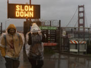 Samarth Jadhav, left, and Parvin Aktar visit the Golden Gate Bridge while on a trip from India during a rain storm in San Francisco on Wednesday, Jan. 31, 2024.