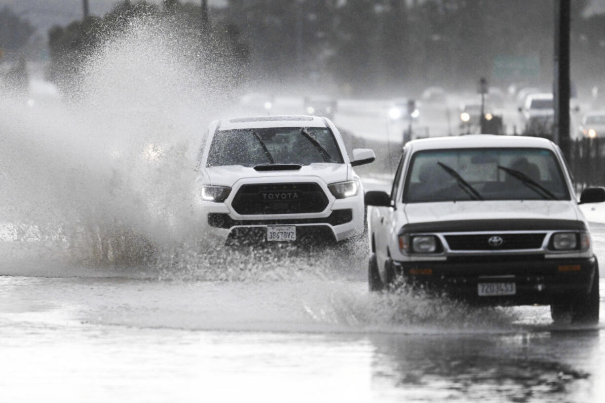 Trucks drive down a flooded street, Tuesday, Feb. 6, 2024, in Lakeside, Calif. The National Weather Service issued a tornado warning for parts of East San Diego county including Lakeside.