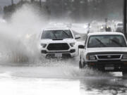 Trucks drive down a flooded street, Tuesday, Feb. 6, 2024, in Lakeside, Calif. The National Weather Service issued a tornado warning for parts of East San Diego county including Lakeside.