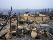 Garden gnomes are lined up in front of homes that were burnt when forest fires reached El Olivar neighborhood in Vina del Mar, Chile, Monday, Feb. 5, 2024. Areas around Vina del Mar were among the hardest-hit by fires that broke out in central Chile three day earlier, resulting in the deaths of more than a hundred people.