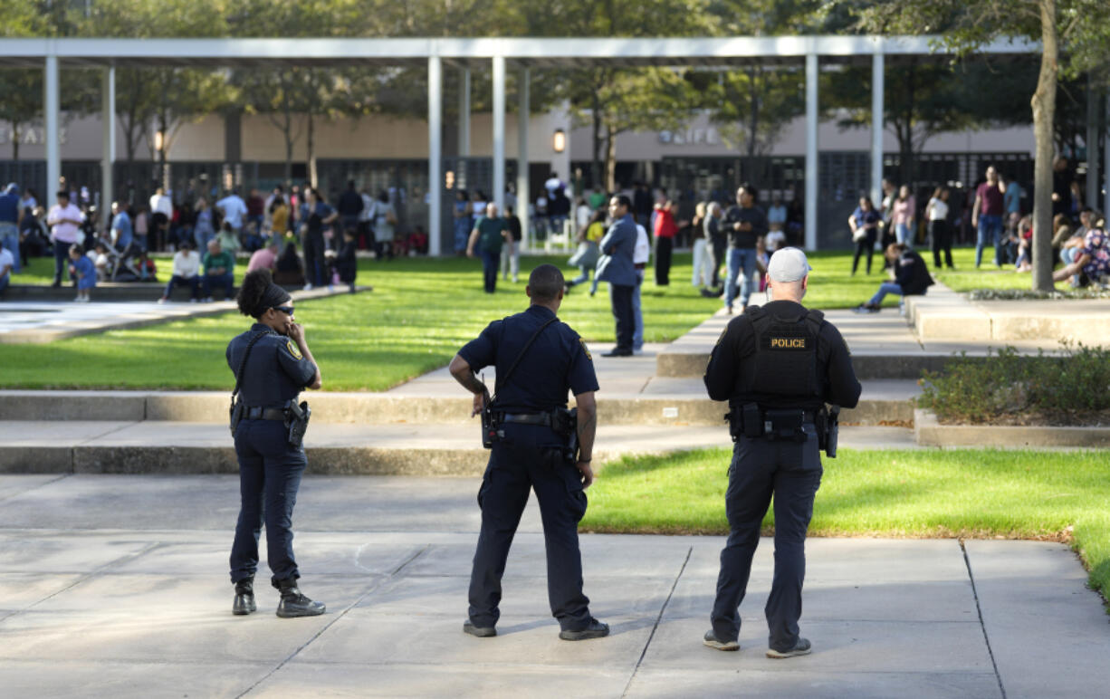 Houston Police officers watch over displaced churchgoers outside Lakewood Church, Sunday, Feb. 11, 2024, in Houston, after a reported shooting during a Spanish church service.