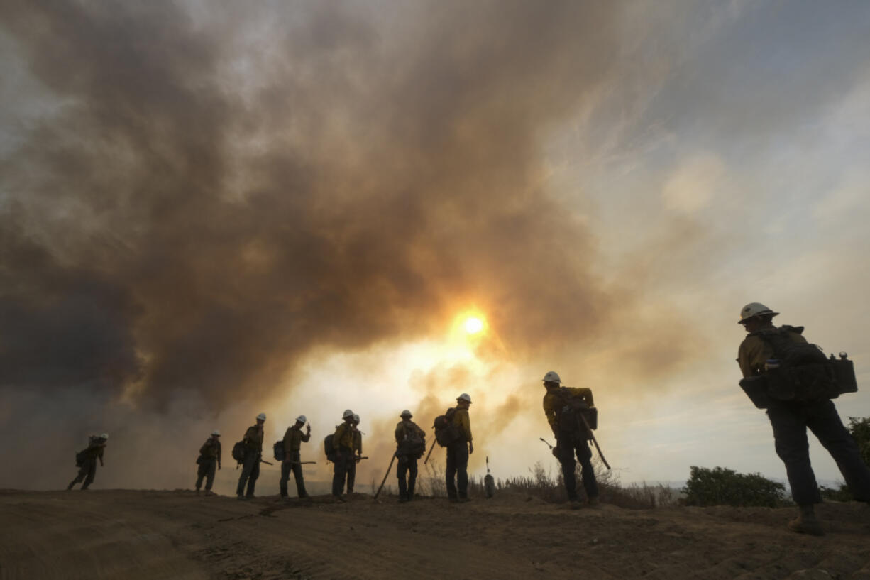 FILE - Firefighters watch as the Fairview Fire burns on a hillside, Sept. 8, 2022, near Hemet, Calif. (AP Photo/Ringo H.W.