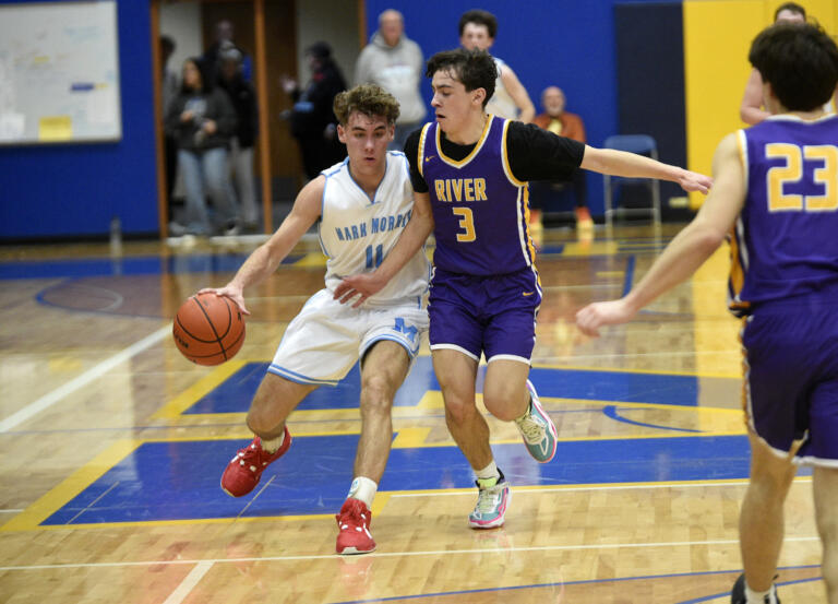 Braydon Olson (11) of Mark Morris works against Ari Richardson (3) of Columbia River in the 2A boys basketball district championship game at Kelso High School on Friday, Feb. 16, 2024.