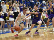Braydon Olson (11) of Mark Morris drivers on Adam Reeder (10) of Columbia River in the 2A boys basketball district championship game at Kelso High School on Friday, Feb. 16, 2024.