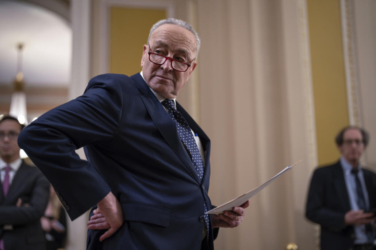 Senate Majority Leader Chuck Schumer, D-N.Y., looks over his notes before speaking reporters following a Democratic caucus meeting, at the Capitol in Washington, Wednesday, Jan. 31, 2024. (AP Photo/J.