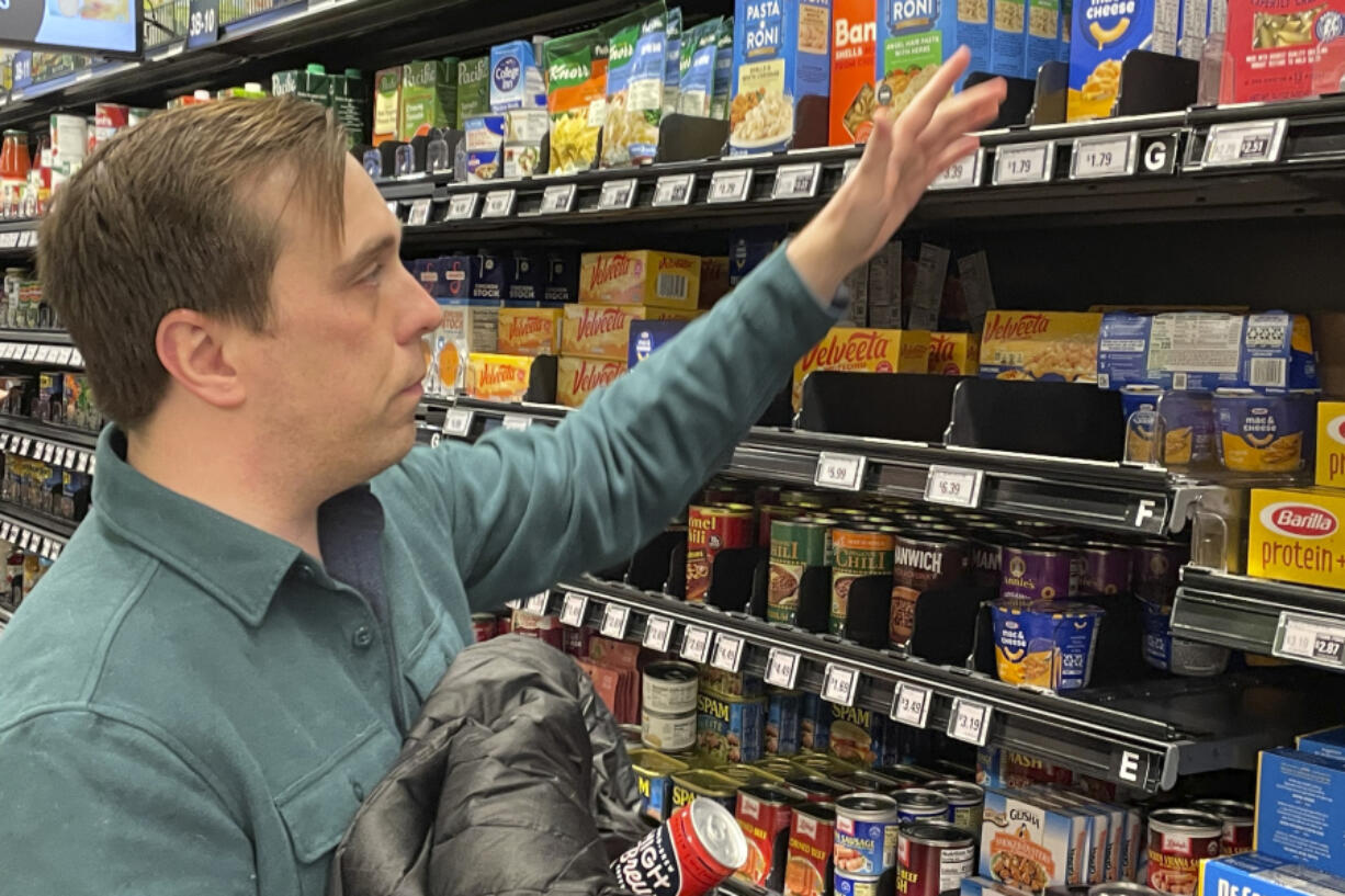 Stuart Dryden reaches for an item at a grocery store on Wednesday in Arlington, Va.