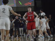 Glacier Peak guard Josiah Lee (2) approaches Camas' Beckett Currie (1) and extends his arm in a sign of sportsmanship as his team celebrates Glacier Peak's 65-61 win over Camas in Wednesday's Round of 12 game at the Tacoma Dome. Currie had a game-high 26 points on 10 of 17 shooting.