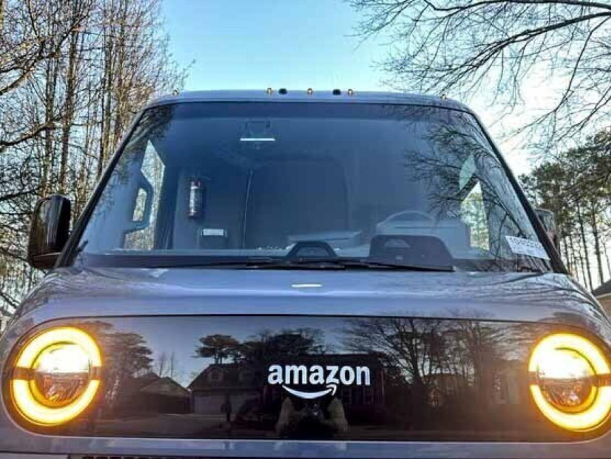 An electric Amazon delivery truck, made by Rivian, is parked during a delivery Wednesday, Jan. 31, 2024, in Kennesaw, Ga. Amazon release results on Thursday, Feb. 1, 2024.