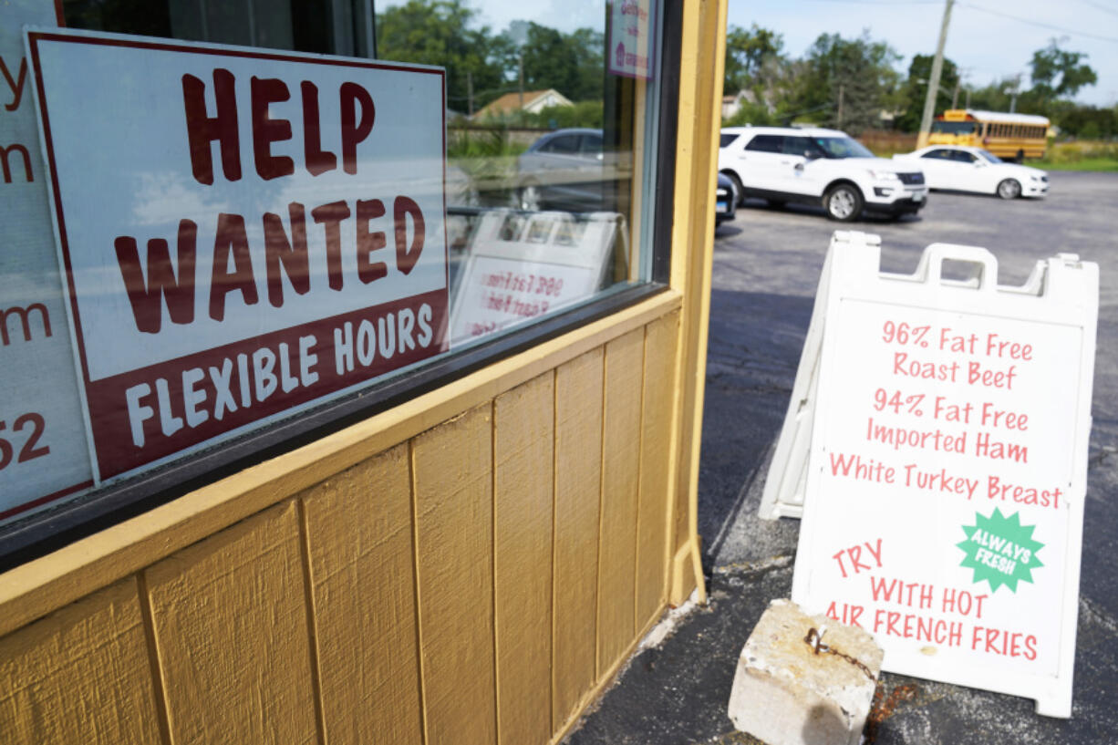FILE - A &ldquo;Help Wanted&rdquo; sign is displayed in Deerfield, Ill., Wednesday, Sept. 21, 2022. The year looks to be a much better one for the U.S. economy than business economists were forecasting just a few months earlier, according to a survey released Monday, Feb. 26, 2024. (AP Photo/Nam Y.