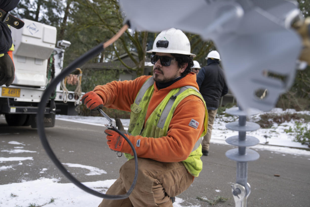 File - A worker from Portland General Electric replaces a power line as crews work to restore power after a storm on Jan. 16, 2024, in Lake Oswego, Ore. On Friday, Feb. 2, 2024, the U.S. government issues its January jobs report.