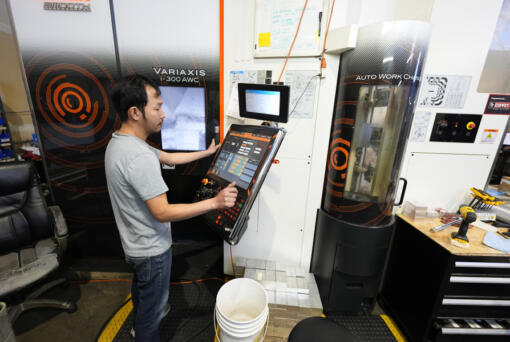 A worker at Reata Engineering and Machine Works programs a Mazak Variaxis machine used to make semiconductor pieces, Thursday, Feb. 15, 2024, in Englewood, Colo. Reata, which supplies the aviation and medical device industries, has invested heavily in software that automates its manufacturing processes. It&rsquo;s also been training workers to use more sophisticated equipment.