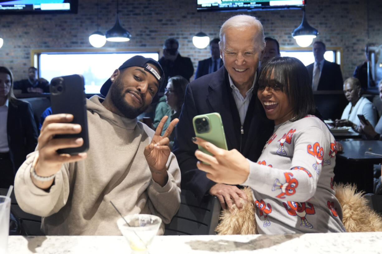 FILE - President Joe Biden, center, takes photos with patrons at They Say restaurant during a campaign stop Feb. 1, 2024, in Harper Woods, Mich. Biden is going small to try to win big in November. With 10 months to go until Election Day, the Democratic incumbent is all in on minimalist events &mdash; visits to a boba tea store, a family&rsquo;s kitchen and a barbershop, for example &mdash; rather than big rallies.