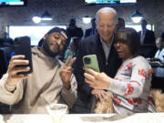 FILE - President Joe Biden, center, takes photos with patrons at They Say restaurant during a campaign stop Feb. 1, 2024, in Harper Woods, Mich. Biden is going small to try to win big in November. With 10 months to go until Election Day, the Democratic incumbent is all in on minimalist events &mdash; visits to a boba tea store, a family&rsquo;s kitchen and a barbershop, for example &mdash; rather than big rallies.