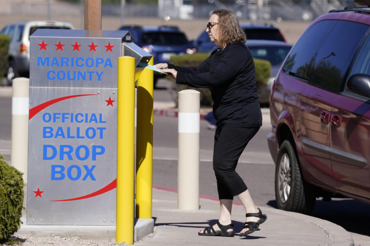 FILE - A voter places a ballot in an election voting drop box in Mesa, Ariz., Oct. 28, 2022. According to a bipartisan report released Tuesday, Feb. 6, 2024, that calls for greater transparency and steps to make voting easier, a &ldquo;tumultuous period of domestic unrest&rdquo; combined with a complicated and highly decentralized election system has led to a loss of faith in election results among some in the U.S. (AP Photo/Ross D.