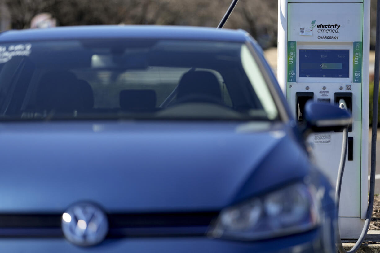 A Volkswagen electric vehicle connects to an Electrify America charging station, Friday, Feb. 2, 2024, in Kennesaw, Ga., near Atlanta.